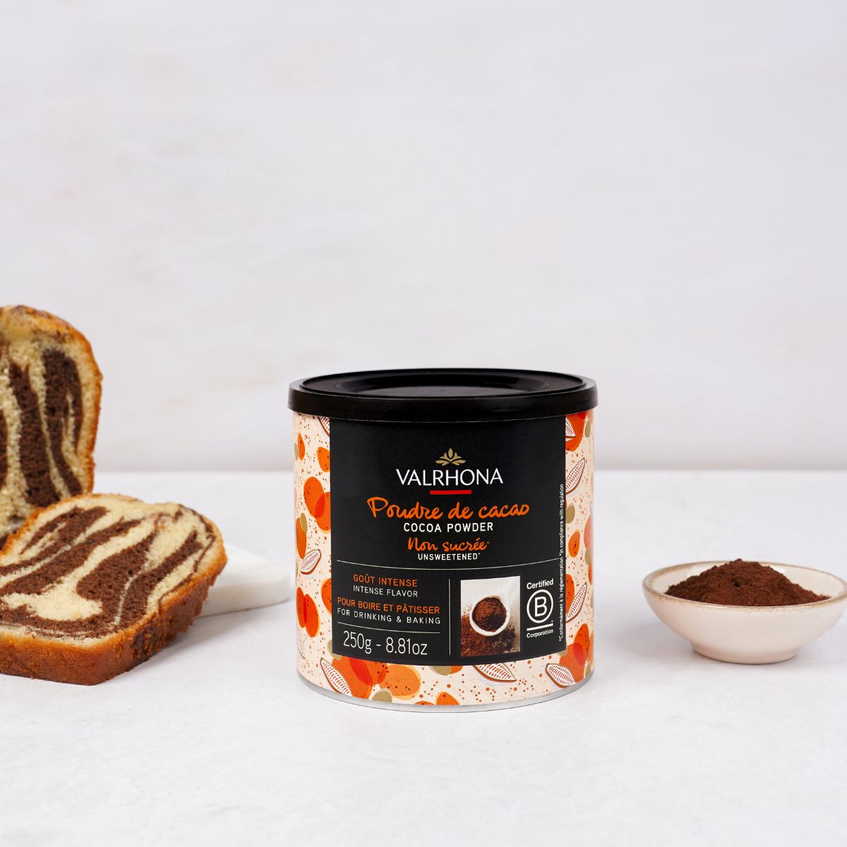 Mise en scène cacao en poudre sur plan de travail avec un gâteau marbré