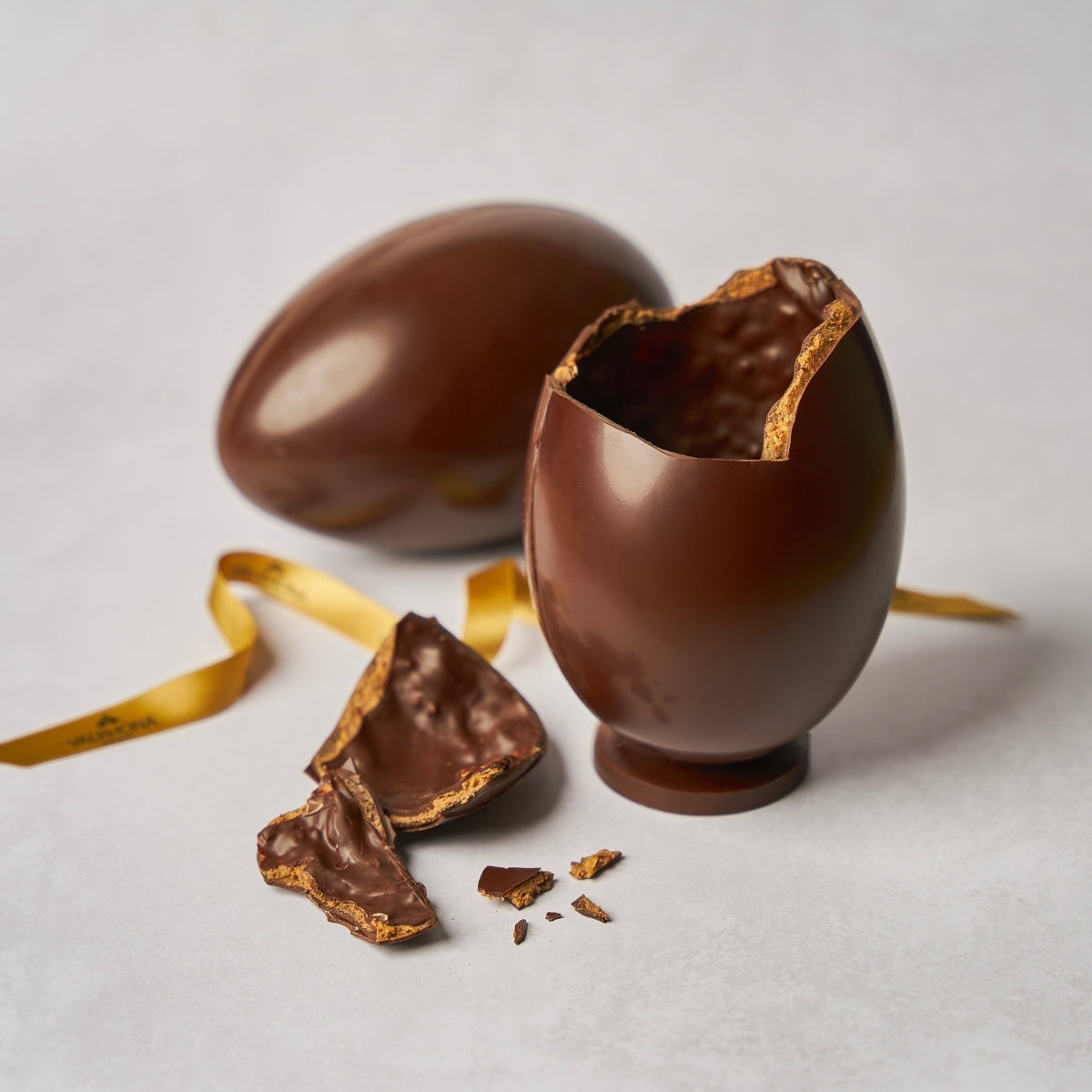 Oeuf de pâques en chocolat cassé sur le haut avec morceaux de chocolat à côté