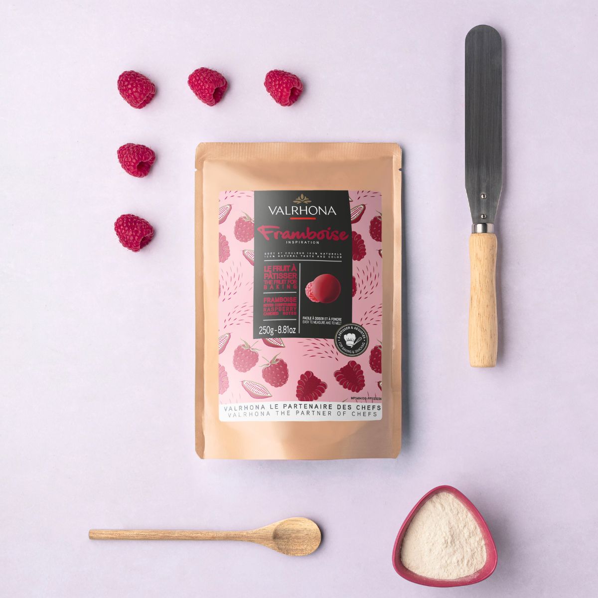 sachet inspiration framboise avec ustensiles de pâtisserie disposés autour et framboises fraiches