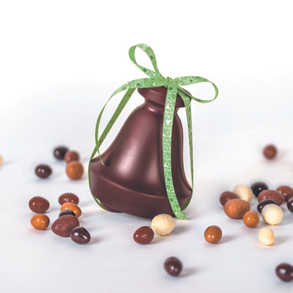 Cloche en chocolat noir avec petits oeufs de pâques à côté