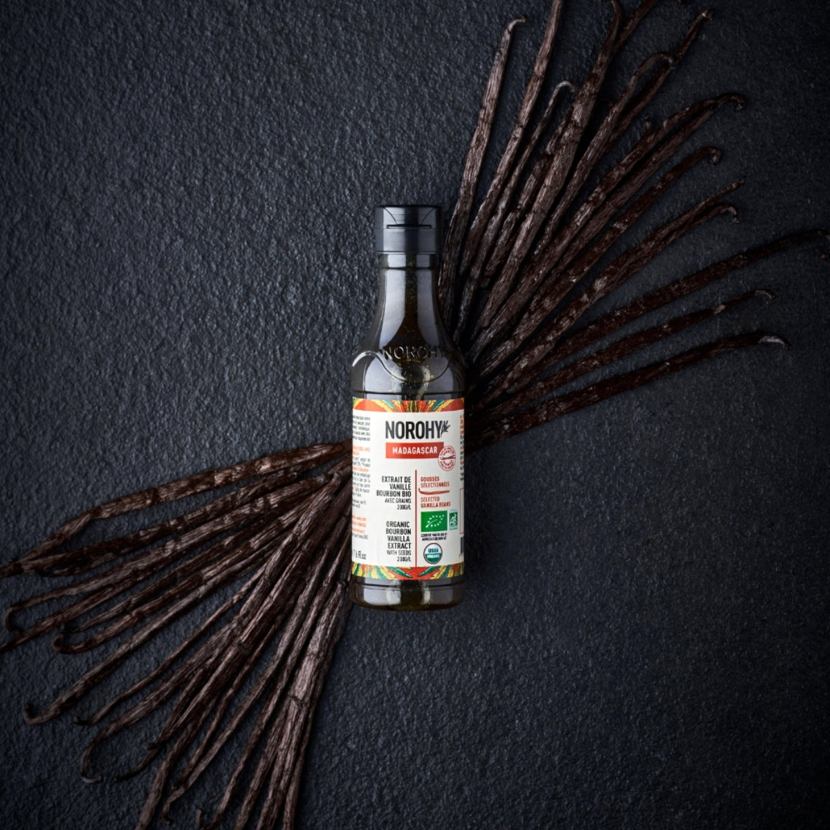 Flacon d'extrait de vanille bourbon bio de Madagascar avec gousses à côté