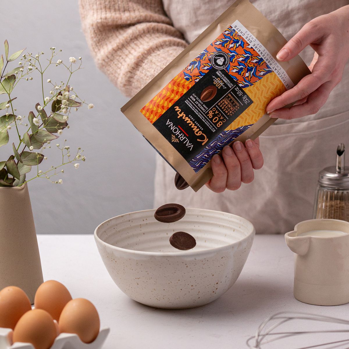 personne qui verse du chocolat Komuntu Valrhona dans un bol