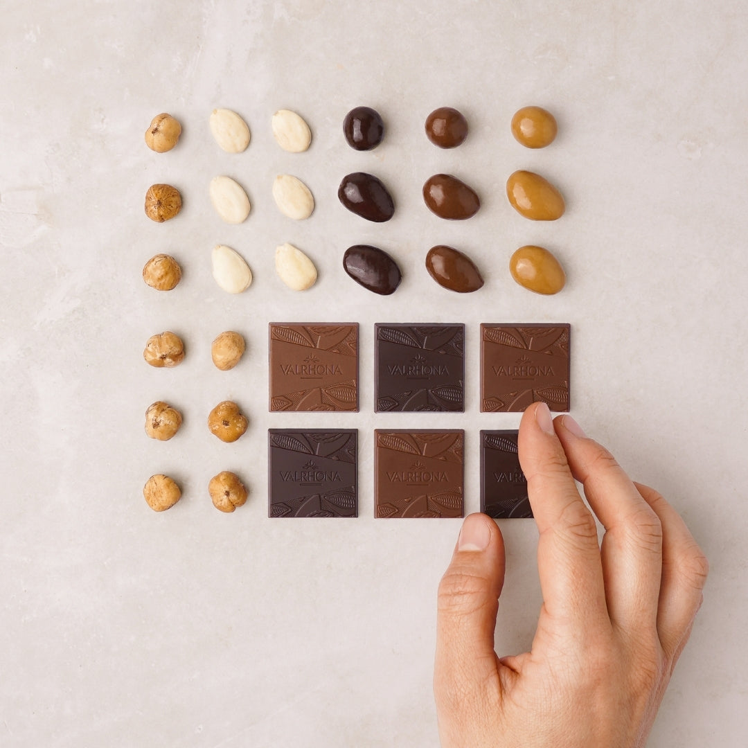 carrés de chocolats, fruits secs enrobés de chocolat, amandes et noisettes alignés