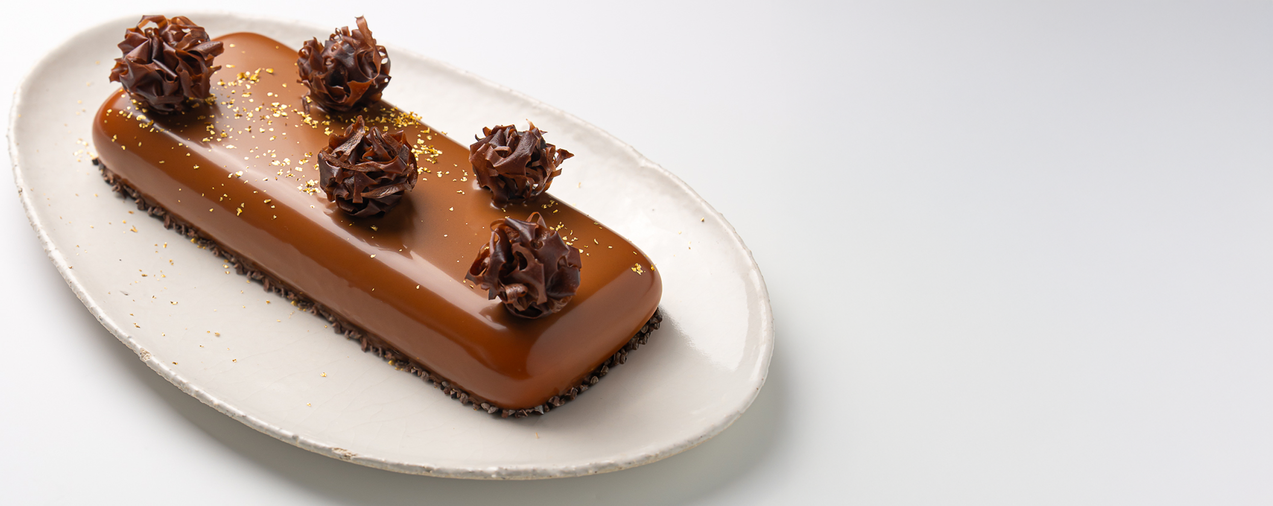 buche avec glaçage miroir chocolat et petits décors croustillants